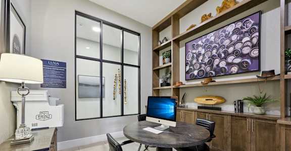 A modern office with a round table and a computer on it.