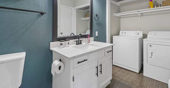 A bathroom with a white sink and a white toilet.