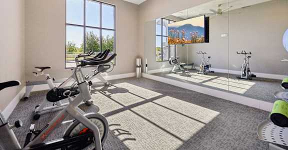 A spacious home gym with exercise equipment and a large window.