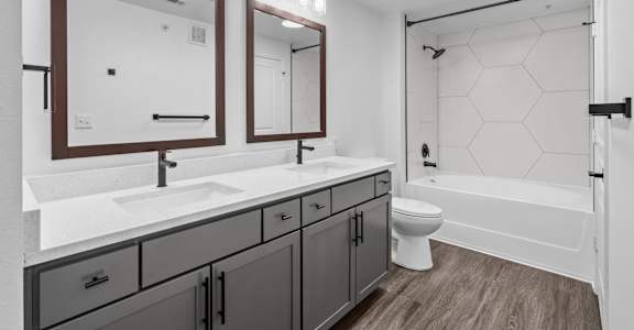 A bathroom with a white sink and a white toilet.