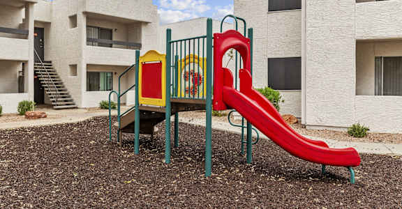 a playground with a slide and slides in an apartment building