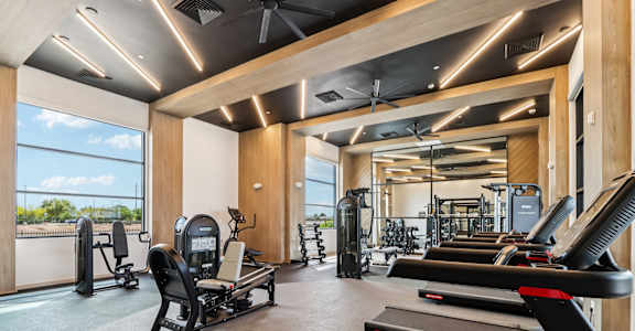 A gym with treadmills, weights, and exercise equipment at Ironwood Ranch Apartments,Arizona.