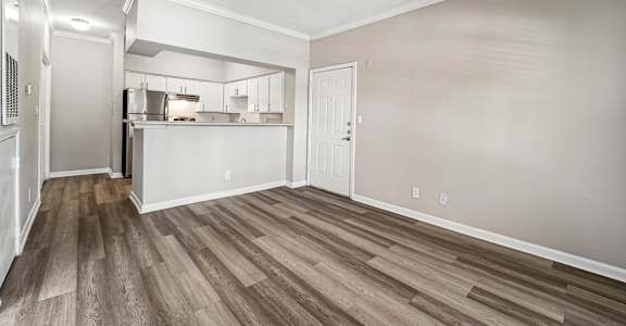 A room with wooden flooring and white walls.