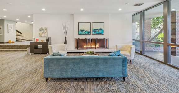 A modern living room with a fireplace and a blue couch.