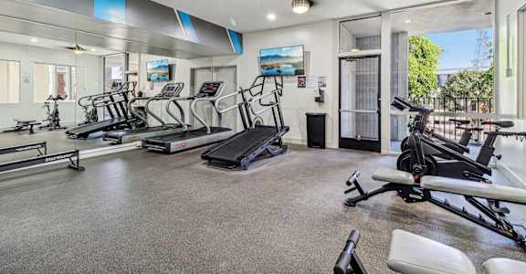 A spacious home gym with treadmills, elliptical machines, and other exercise equipment.