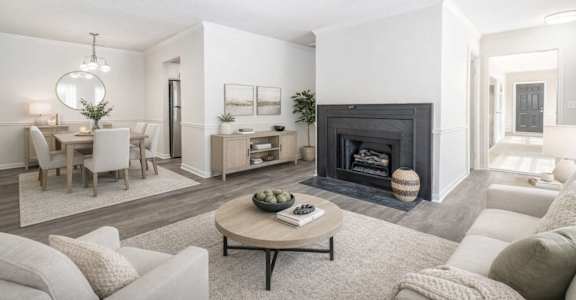 A modern living room with a fireplace and a dining area.