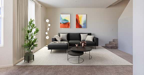 A living room with a black couch, a small table, and a painting on the wall at The Woods Apartments, California, 95136
