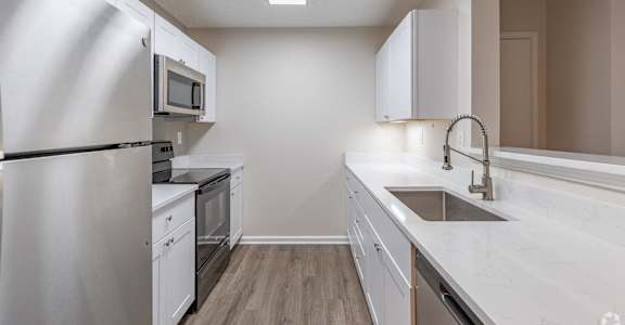 A modern kitchen with white appliances and cabinets.