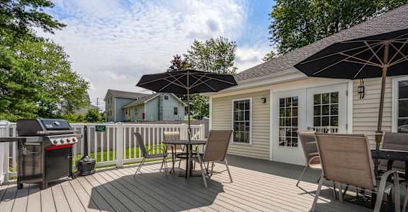 A wooden deck with chairs and an umbrella.