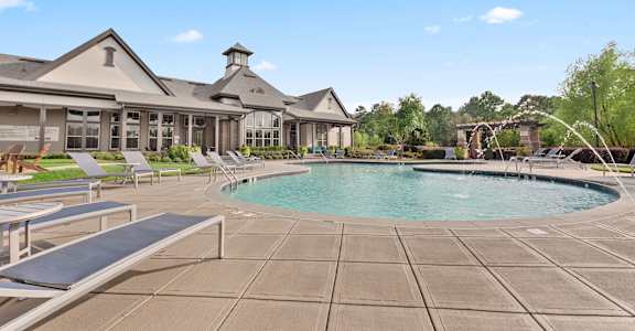 a resort style pool with lounge chairs and a building in the background at The Ridge at Chenal Valley, Little Rock, Arkansas