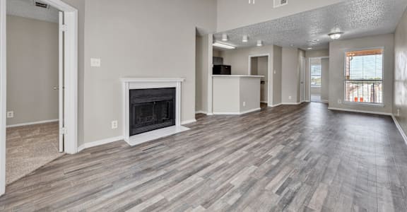 A spacious living room with a fireplace and hardwood floors.