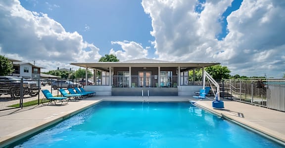 A large swimming pool with a building in the background.