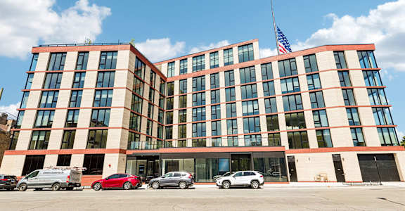 A large building with a red car parked in front of it.