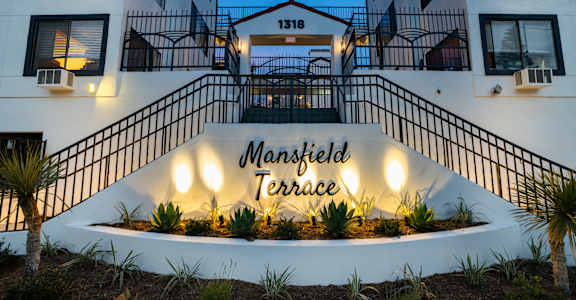 an image of the front entrance of the terrace apartment building at night