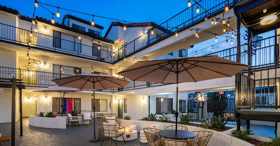 a patio with tables and chairs and umbrellas at night