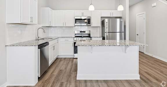 A modern kitchen with white cabinets and stainless steel appliances.
