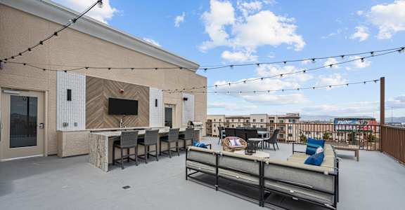the patio of a building with tables and chairs and a bar