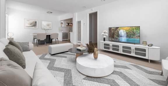 A modern living room with a white couch and a large television.