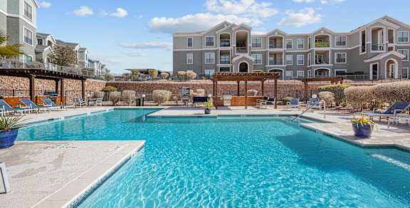 a swimming pool with an apartment building in the background