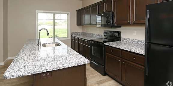 Kitchen with brown wooden cabinets at Fountain Ridge, Pleasant Prairie