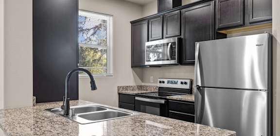 a kitchen with stainless steel appliances and granite counter tops