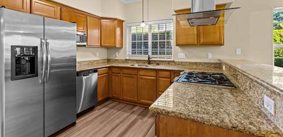 an updated kitchen with stainless steel appliances and granite counter tops