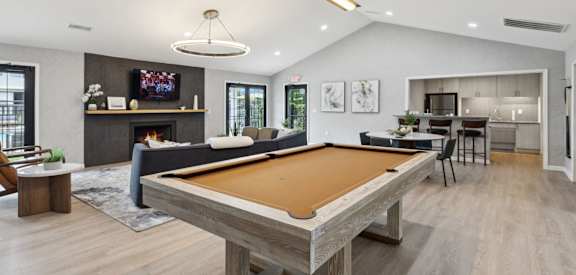 A pool table is in the middle of a living room.