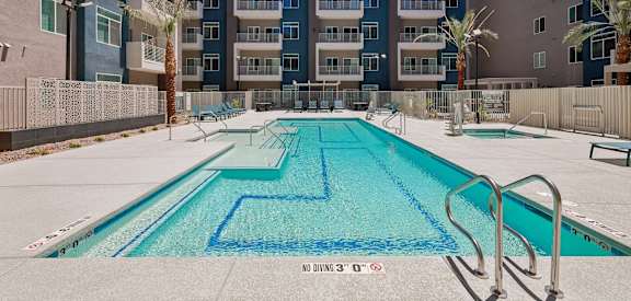A swimming pool with a blue tiled bottom and a metal ladder on the right side.