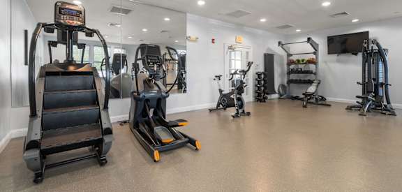 A gym with treadmills, exercise bikes, and other equipment.