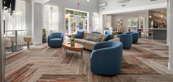 A spacious living room with a variety of seating options and a flat-screen TV.