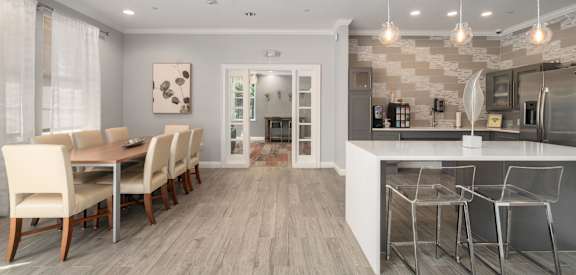 A modern kitchen and dining room with a wooden floor and white walls.