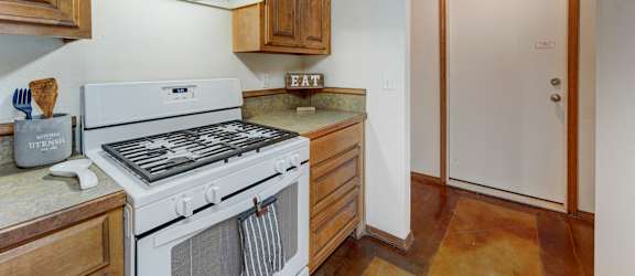 a kitchen with wooden cabinets and white appliances