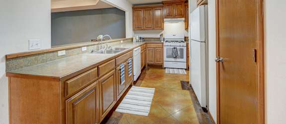 a kitchen with wooden cabinets and white appliances