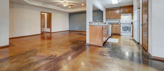 a kitchen and living room with white walls and wood floors