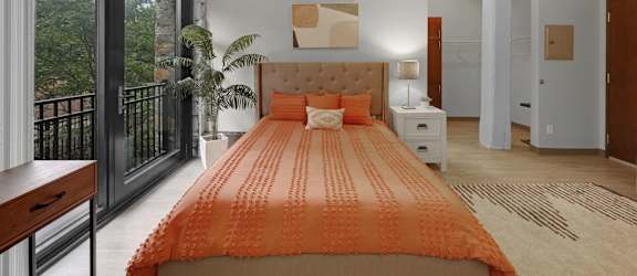 a bedroom with an orange bed and a balcony