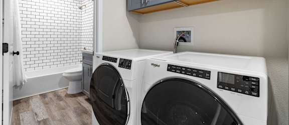 a washer and dryer in a laundry room with a sink and a toilet