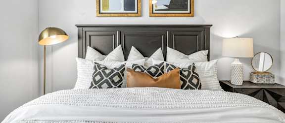 a bedroom with a bed and two paintings on the wall