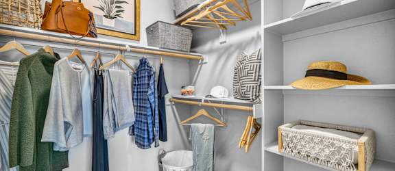 a walk in closet with shelves and a basket on the floor