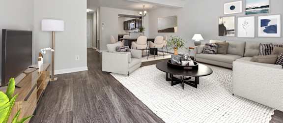 A living room with a brown floor and a white ceiling.