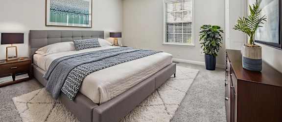 A bedroom with a large bed and a ceiling fan.