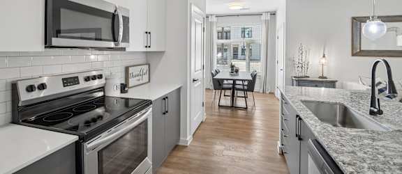 A modern kitchen with a stove top oven and microwave.