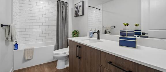 A white bathroom with a toilet, sink, and a mirror.