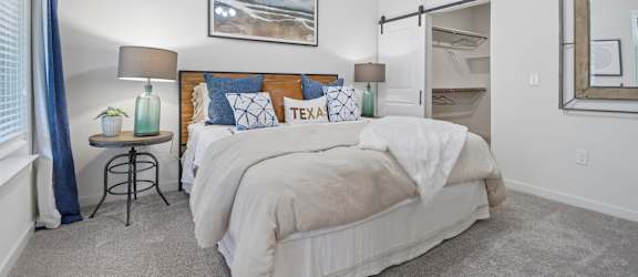 A bedroom with a large bed and a ceiling fan.