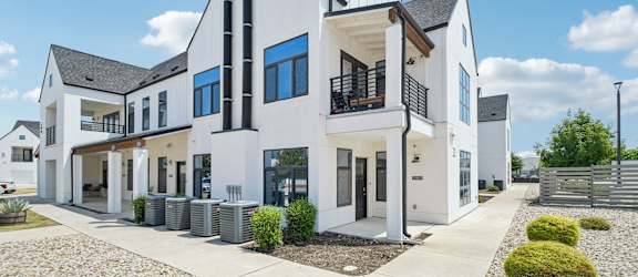 A modern white house with black accents and a black chimney.