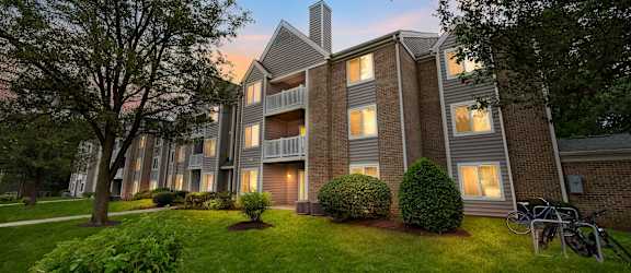 an apartment building with windows lit up at dusk