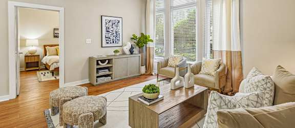 A living room with a brown sofa, a wooden coffee table, and a painting on the wall.