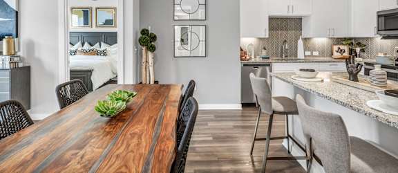A modern kitchen with a wooden dining table and chairs.
