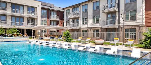 A swimming pool in front of apartment buildings.