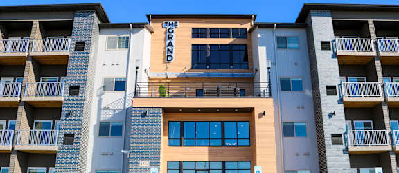 an apartment building with a blue sky in the background at Upscale Living at the Grand off 45th, Fargo, 58104