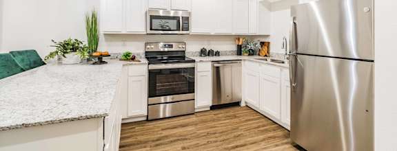 a kitchen with white cabinetry and stainless steel appliances